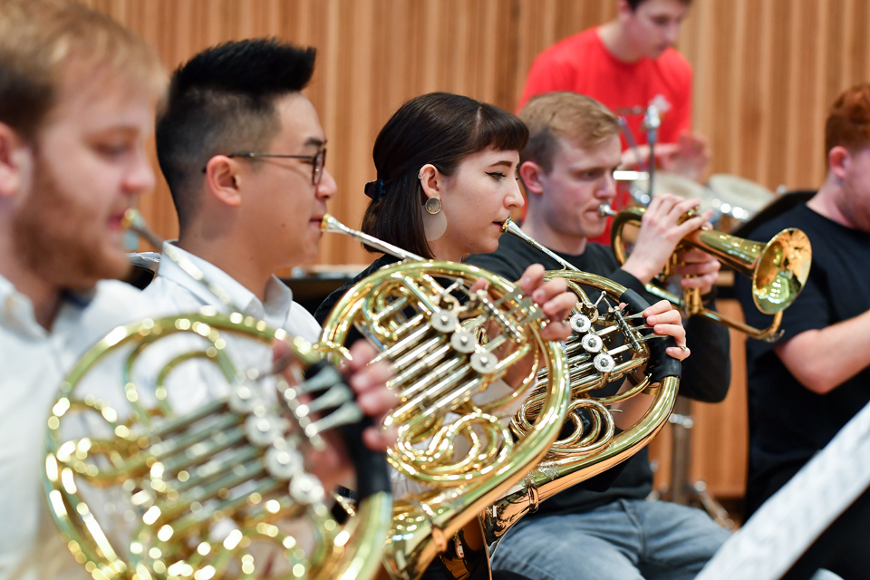 A group of Brass students, performing on French horns.